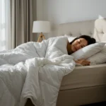 Restful Sleep with Cooling Bamboo Bedding Woman sleeping peacefully under a soft white bamboo duvet in a bright, cozy bedroom.